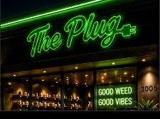 The Plug storefront neon sign